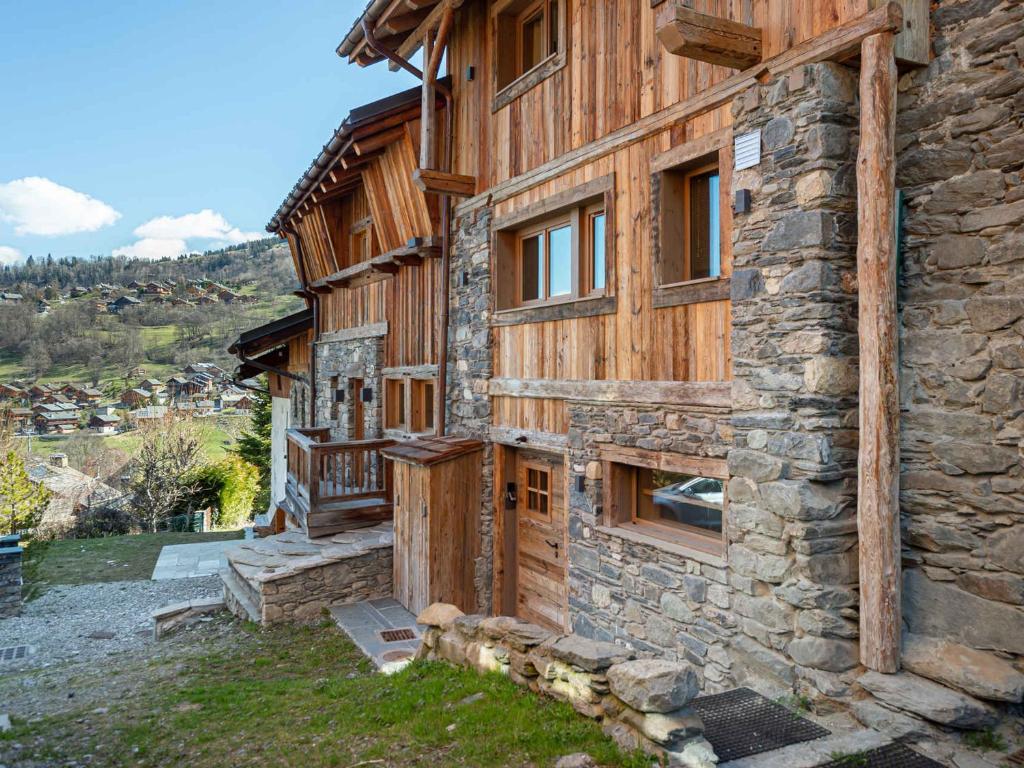 - un bâtiment en bois avec une terrasse couverte sur le côté dans l'établissement Chalet cosy au Raffort avec jardin, proche télécabines et bus, parking, animaux admis - FR-1-566-47, à Les Allues