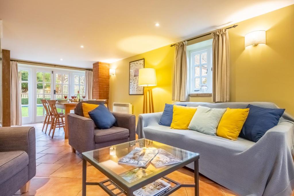 a living room with a couch and a table at Garden Cottage in Ringstead