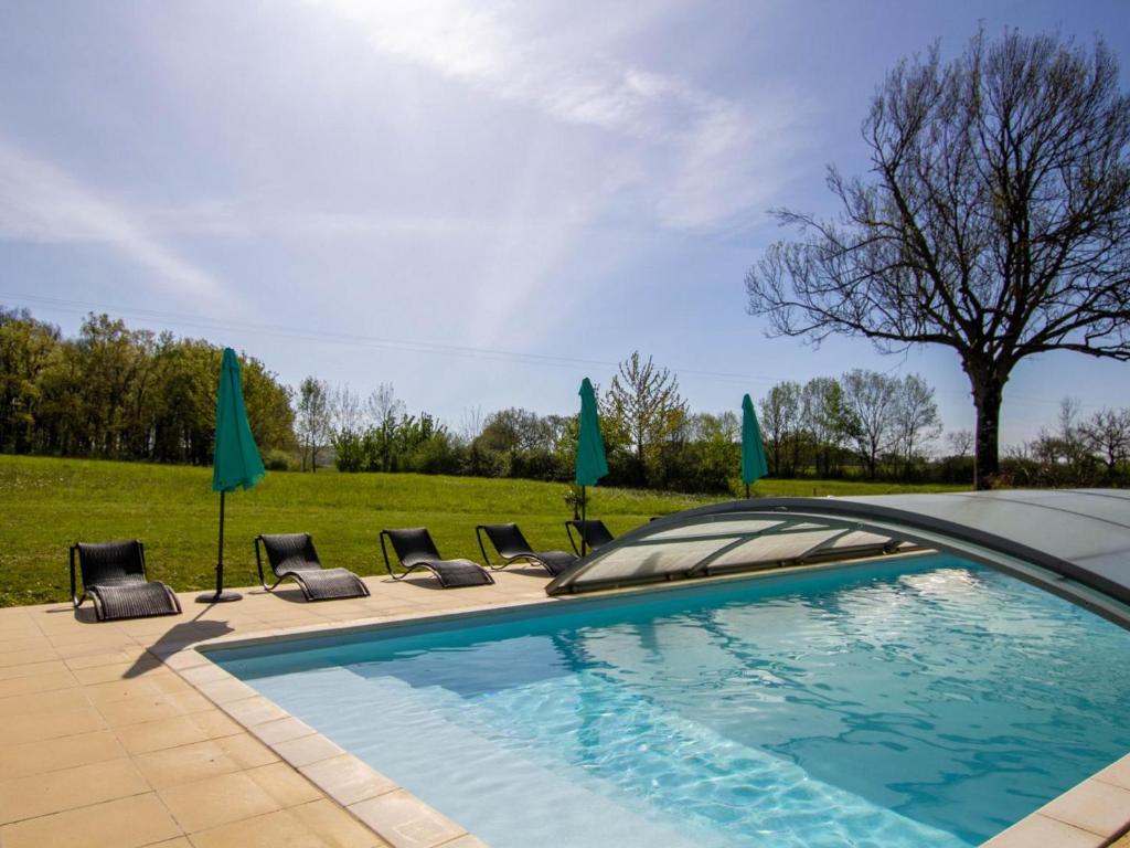 einen Pool mit Liegestühlen und Sonnenschirmen in der Unterkunft Gîte Naussannes, 2 pièces, 2 personnes - FR-1-616-194 in Naussannes