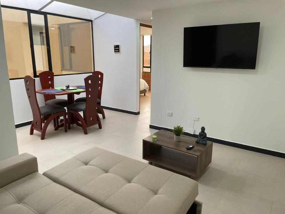 een woonkamer met een bank en een tafel bij Encantador apartamento #2 cerca al aeropuerto in Bogota