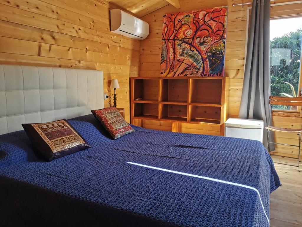 a bedroom with a blue bed in a wooden cabin at B&B Parco degli Ulivi in Misano Adriatico