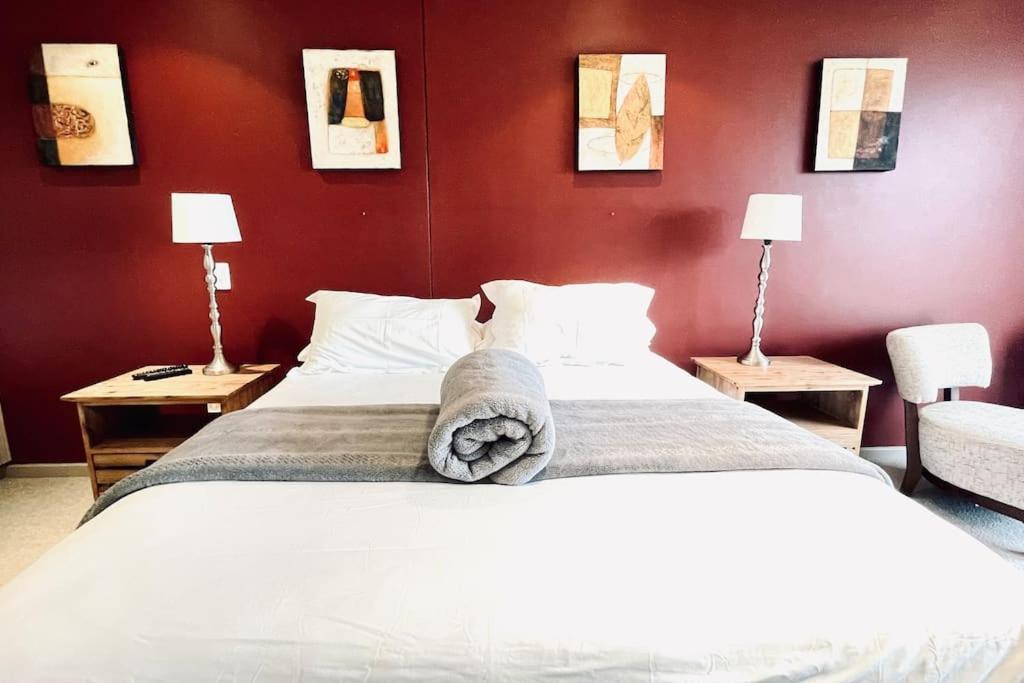 um quarto com uma cama grande e paredes vermelhas em Exquisite Villa at Pinnacle em Mossel Bay