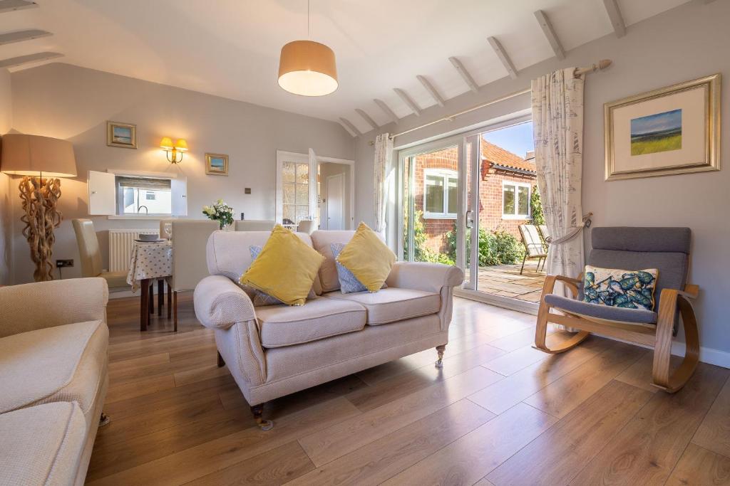 a living room with a couch and a window at Sea Lodge in Brancaster