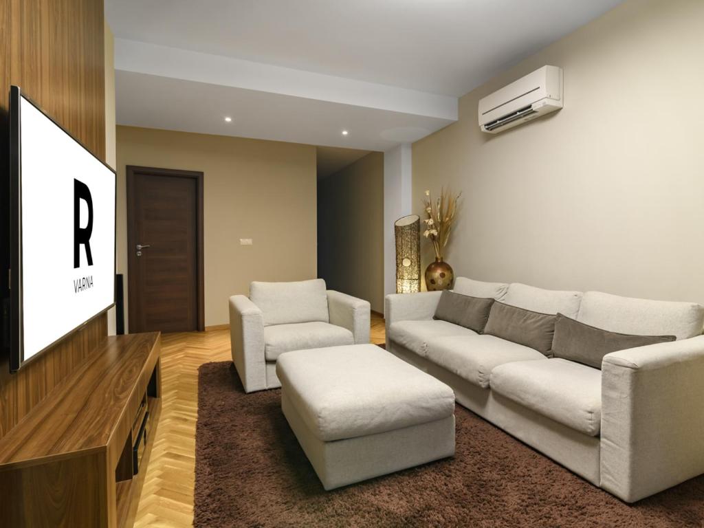a living room with a couch and two chairs and a tv at Beachfront 3-bedroom apartment with jaccuzi and barbecue in the back in Varna City
