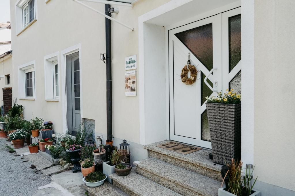 une porte d'entrée d'une maison avec des plantes en pot dans l'établissement Ferienhaus Ricki, à Rust
