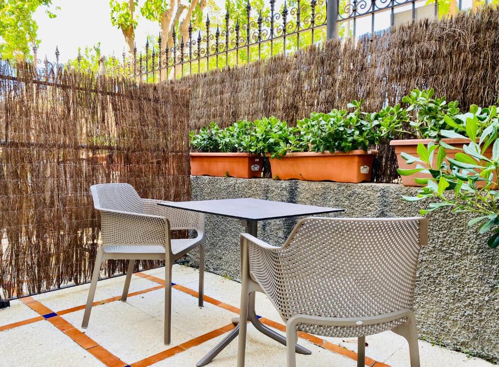two chairs and a table in a patio with plants at Apartamentos Turísticos Santo Rostro in Chipiona