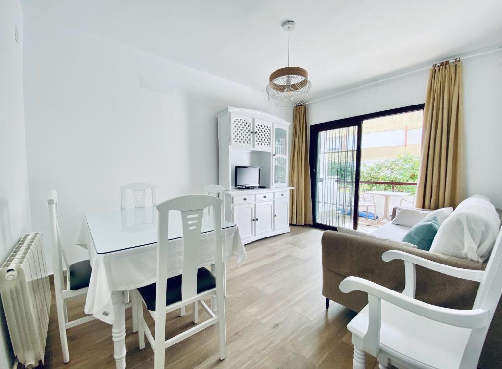 a kitchen and living room with a table and a couch at Apartamentos Turísticos Santo Rostro in Chipiona