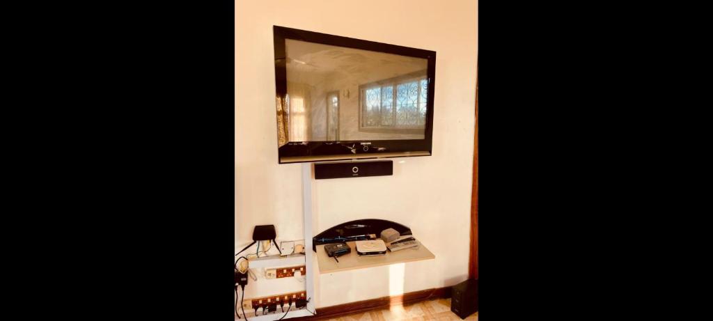 TV de pantalla plana colgada en la pared en SALAAM LETTING (4 BEDROOM, ZANZIBAR HOUSE), en Kiembi Samaki