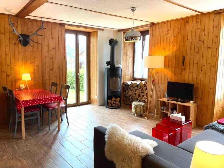 uma sala de estar com um sofá, uma mesa e uma televisão em Charmant 2,5 pièces avec jardin à 2 pas du lac em Champex