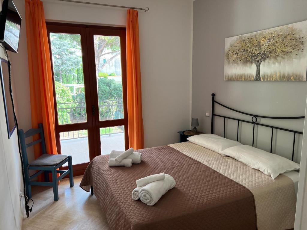 Villa Aileen في ماكاري: غرفة نوم عليها سرير وفوط