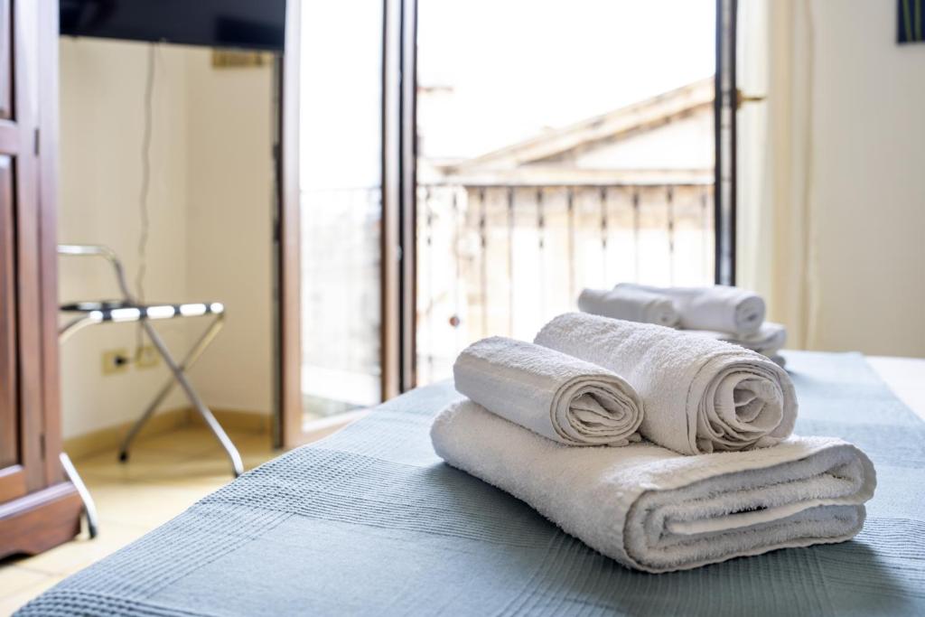 a pile of towels sitting on top of a bed at Porta Carini in Palermo