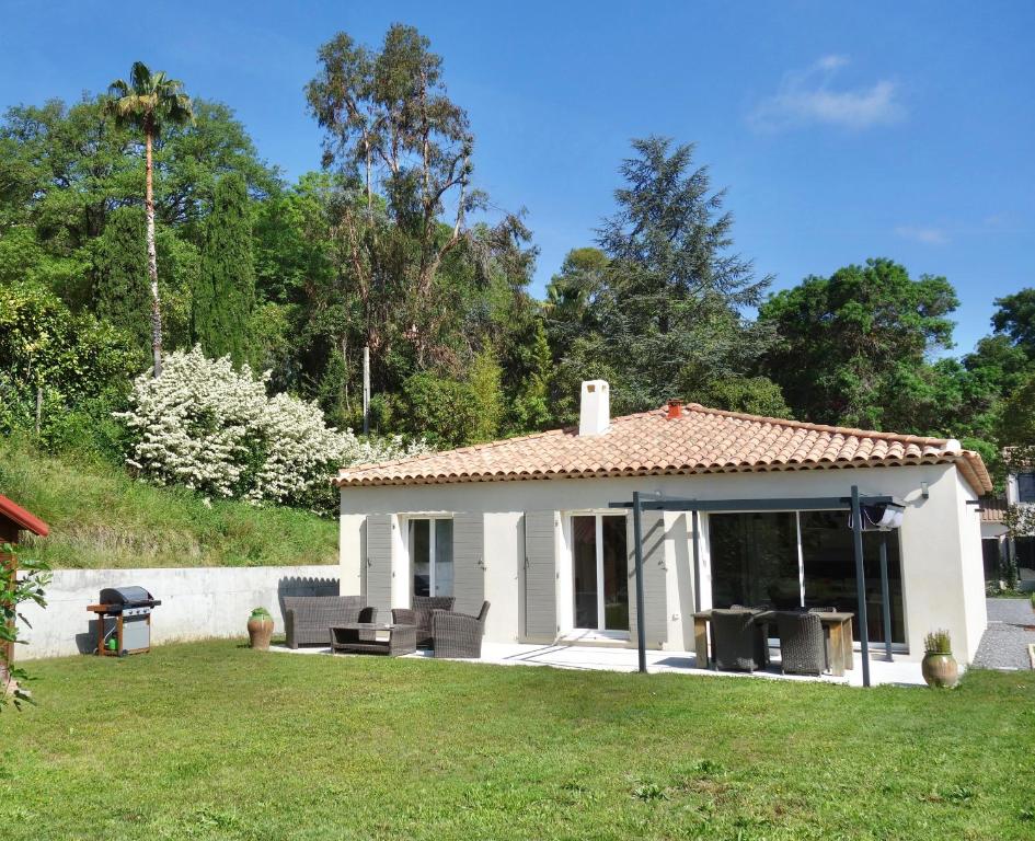 ein kleines weißes Haus mit Rasen in der Unterkunft Les Yuccas -Maison neuve avec un jardin à Saint Paul de Vence in Saint-Paul-de-Vence