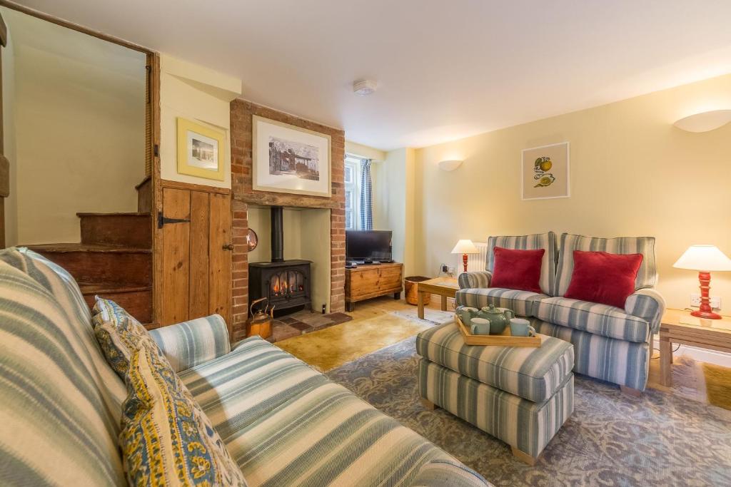 a living room with two couches and a fireplace at 1 Honeymoon Row in Wells next the Sea