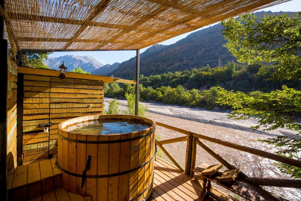 d'un bain à remous sur une terrasse offrant une vue sur la montagne. dans l'établissement Haiku Cabañas Panorámicas, à San José de Maipo