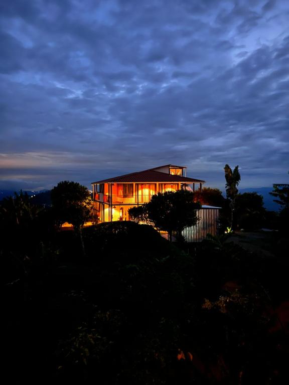 una casa sentada en la cima de una colina por la noche en El Filito, en San JosÃ©