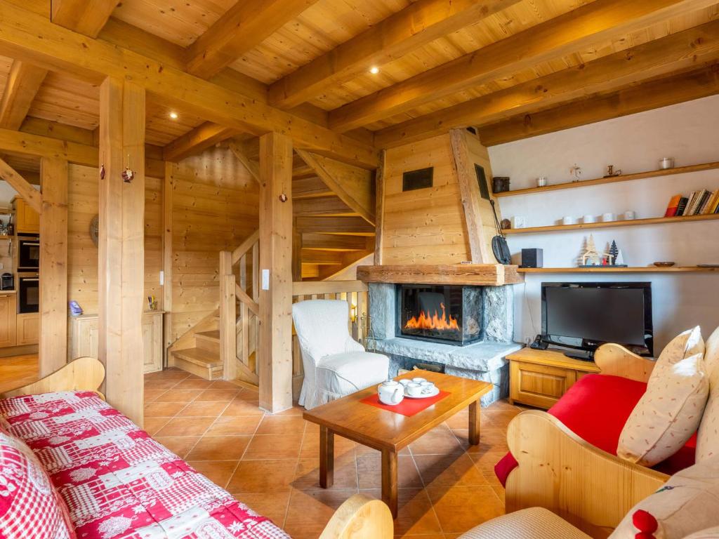 - un salon avec une cheminée dans une cabane en rondins dans l'établissement Chalet mitoyen 3 étoiles à La Clusaz, 500m des pistes, 10 pers, terrasse, cheminée, garage, WiFi - FR-1-459-186, à La Clusaz