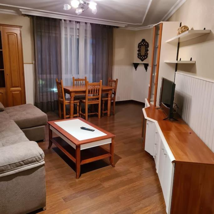 uma sala de estar com um sofá e uma mesa em piso en noia em Noya