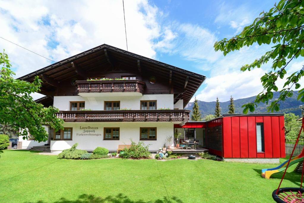 uma casa com um edifício vermelho e branco em Landhaus Zoppoth em Kötschach