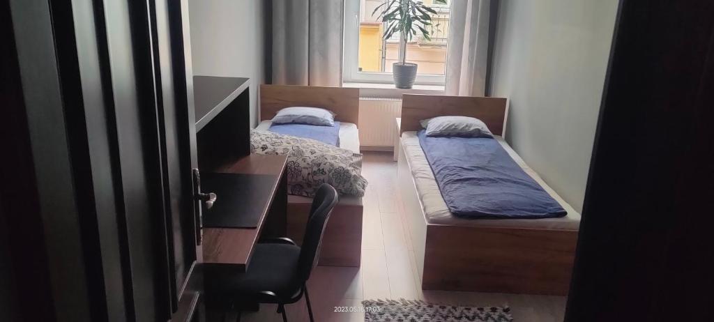 two beds in a room with a window and a chair at Lovely apartment on Dyrekcyjna street! In the very center of Katowice! in Katowice