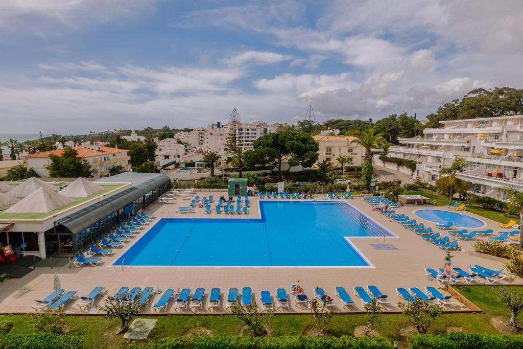 uma vista sobre uma piscina com espreguiçadeiras azuis em Muthu Clube Praia da Oura em Albufeira