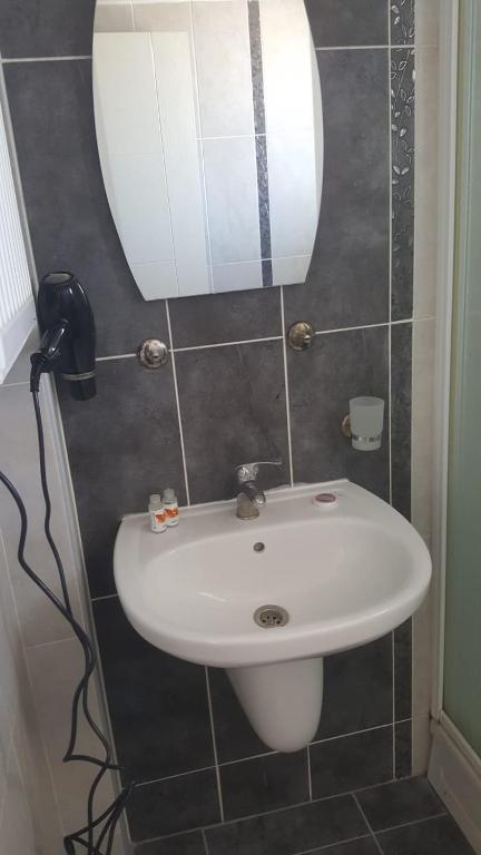 La salle de bains est pourvue d'un lavabo blanc et d'un miroir. dans l'établissement Rainfort Turizm Apart, à Denizli