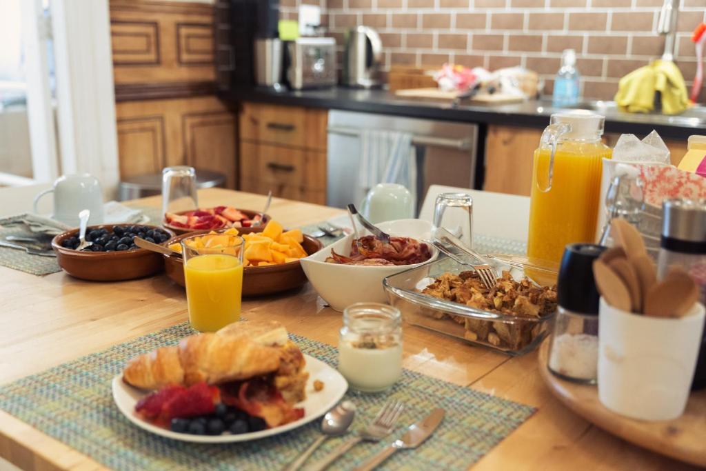 uma mesa coberta com pratos de comida e sumo de laranja em Bed and Breakfast du Village BBV em Montréal