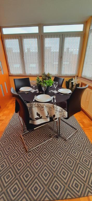 uma sala de jantar com uma mesa e cadeiras num tapete em MyHouseSpain - Apartamento 2 habitaciones cerca de la playa em Gijón
