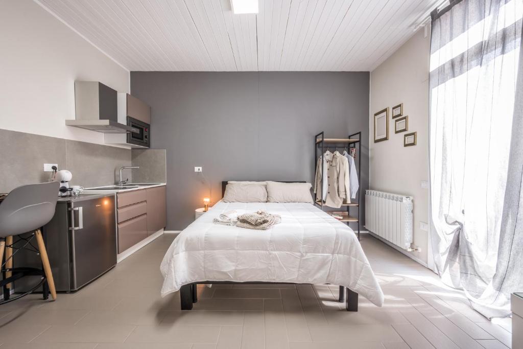 um quarto branco com uma cama e uma cozinha em Suite 649 Mono con terrazzo em Modena