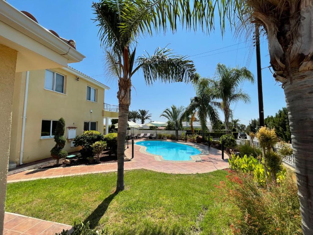 een villa met een palmboom en een zwembad bij Coral Bay new furnished private villa with pool in Peyia