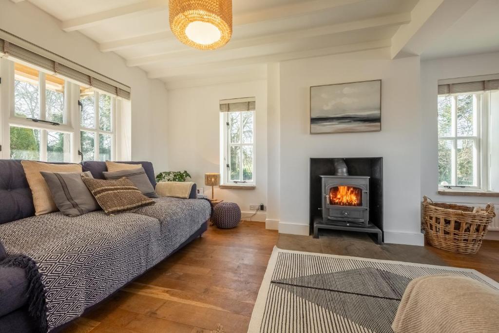a living room with a couch and a fireplace at Marigold Cottage in Docking