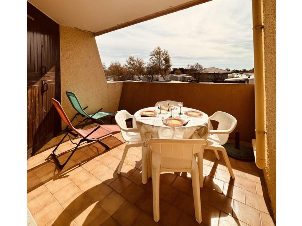 une table blanche et des chaises sur un balcon dans l'établissement Studio Confortable avec Terrasse et Parking Privé, 5 Couchages, Marseillan - FR-1-326-763, à Marseillan