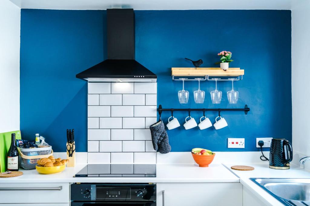 een keuken met een blauwe muur en een fornuis bij Talbot House in Chester