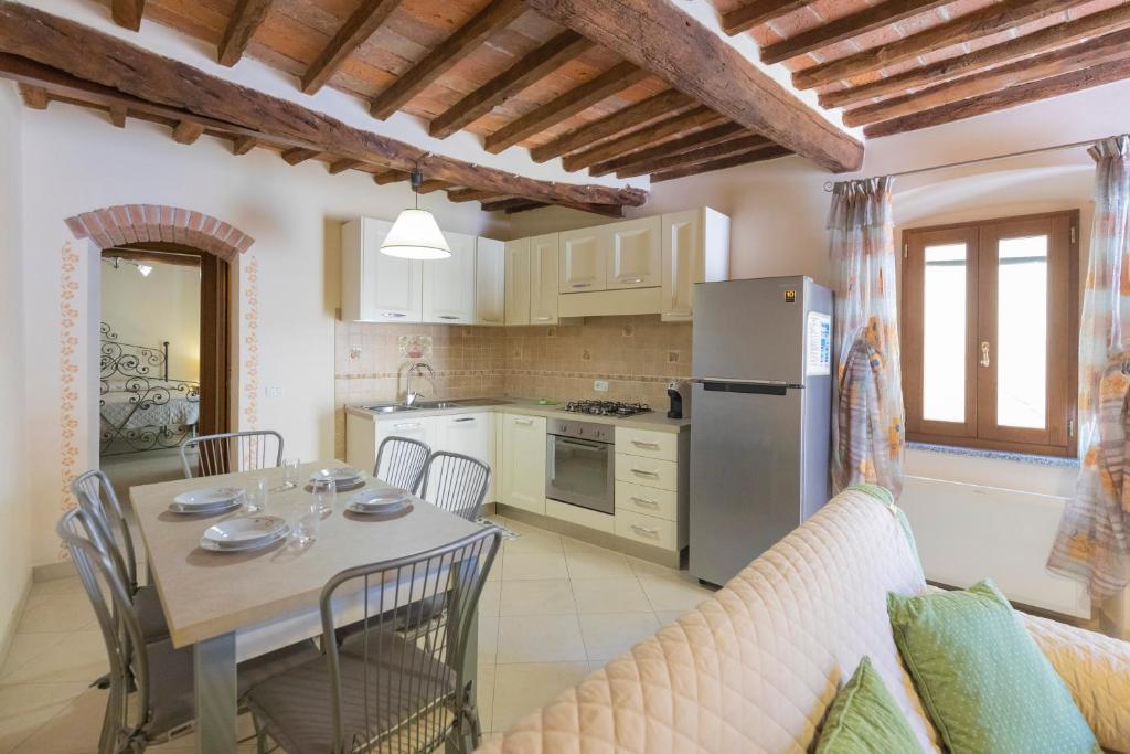 a kitchen and dining room with a table and a couch at Appartamento La Scaletta del Chiasso in Capoliveri