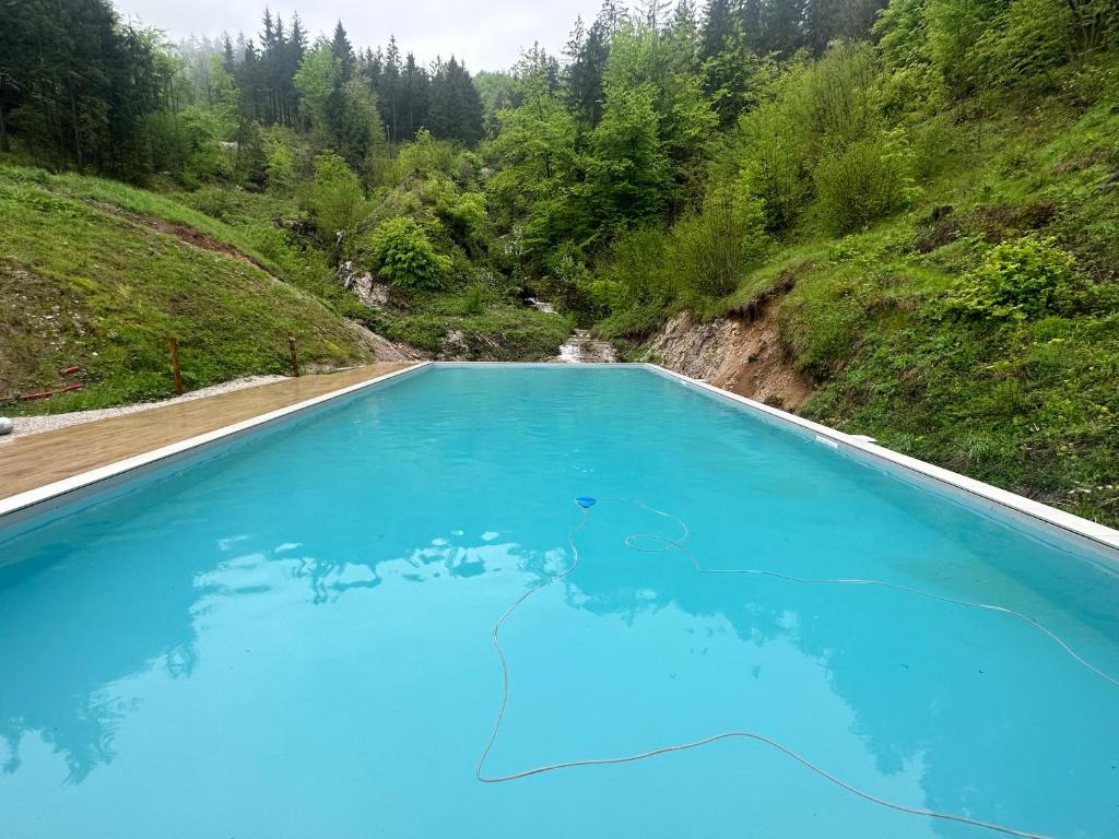 a large pool of blue water in a valley at Chalet HerMes arT in Idrija