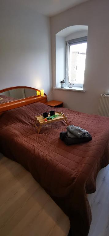 a bedroom with a bed with a red comforter and a window at Kamienica Radków in Radków