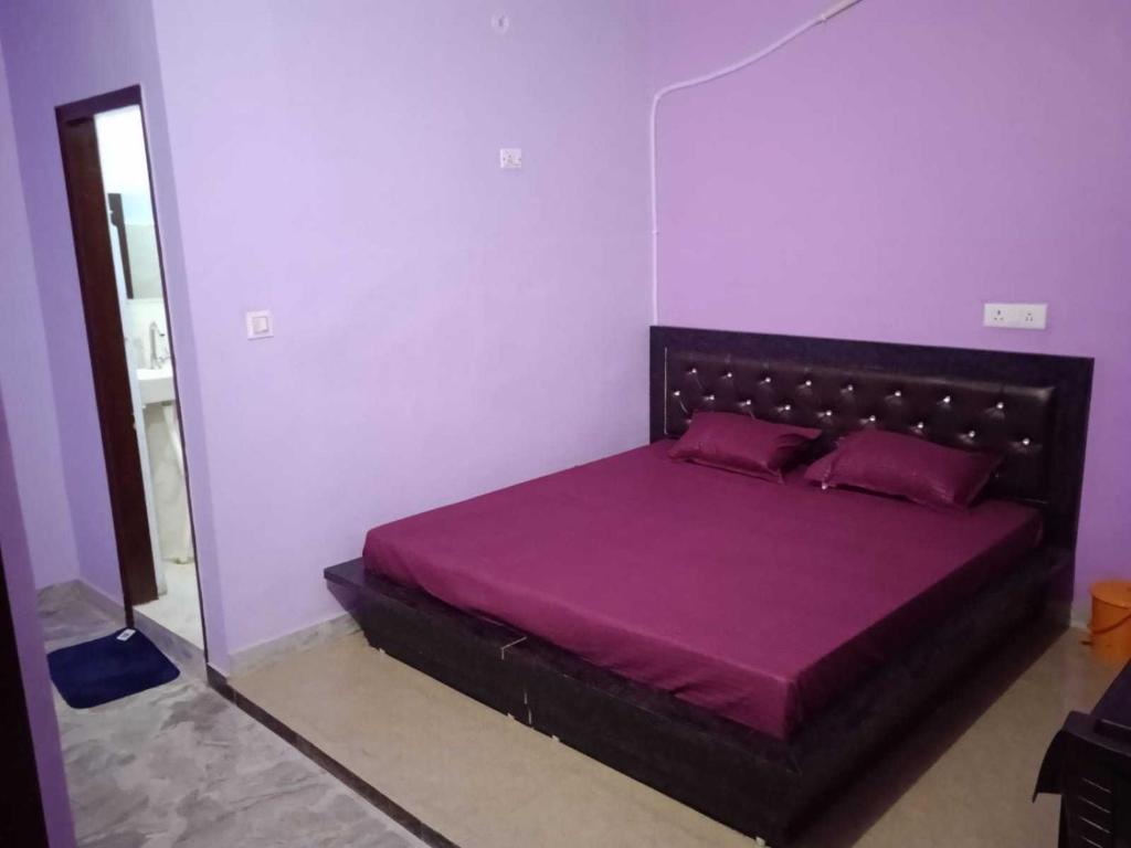 a bedroom with a bed with purple sheets and a mirror at SPOT ON Black Bird in Meerut