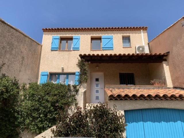 ein großes Gebäude mit blauen Fenstern auf der Seite in der Unterkunft small house 6p in bormes, quiet , hill-view in Bormes-les-Mimosas