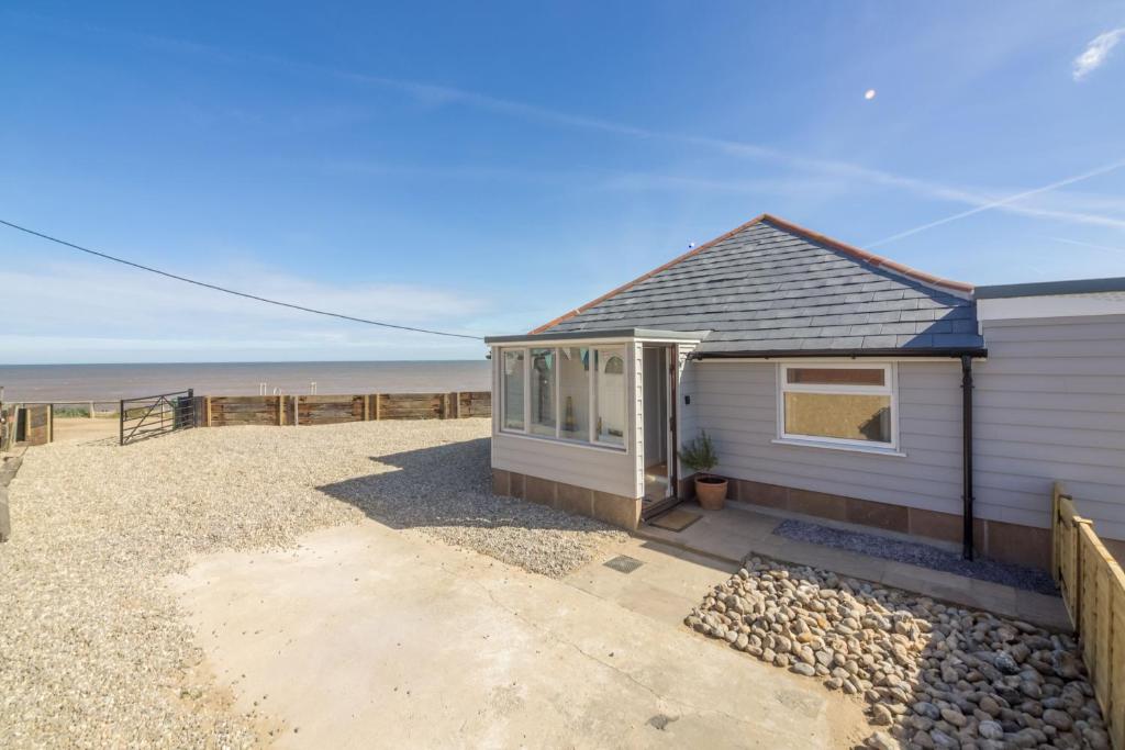 a house on the beach with the ocean in the background at Wyndham Beach House in Walcott