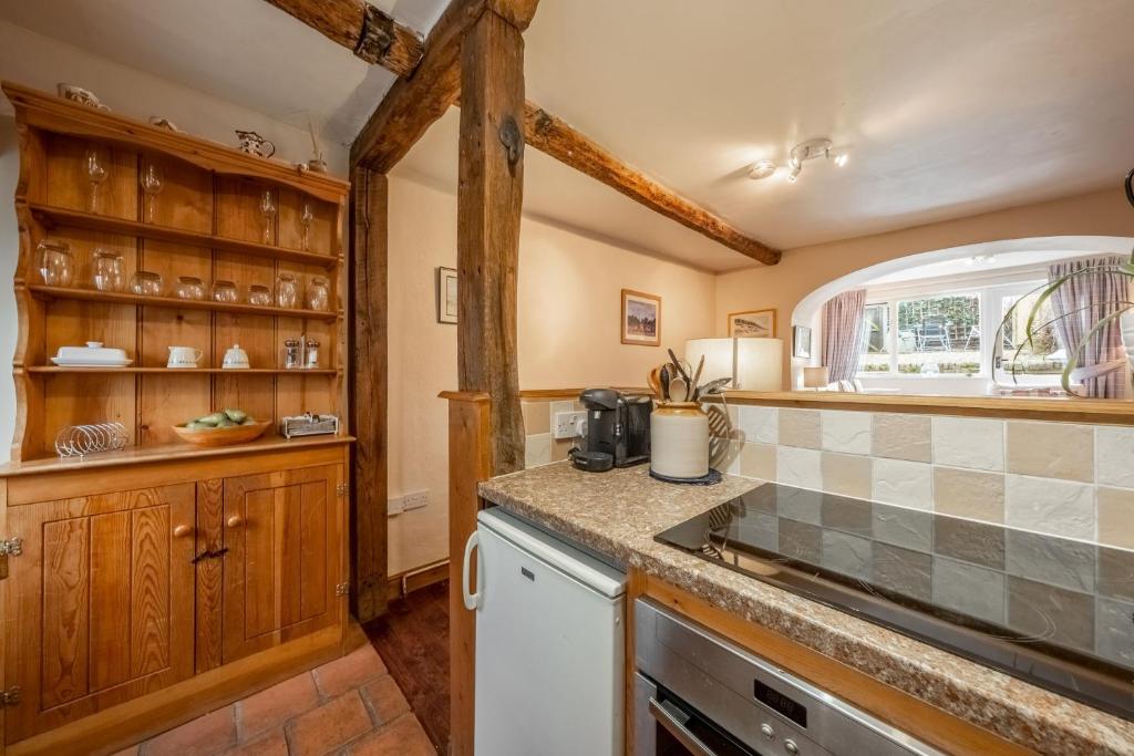 a kitchen with wooden cabinets and a counter top at Harbour View Cottage in Wells next the Sea