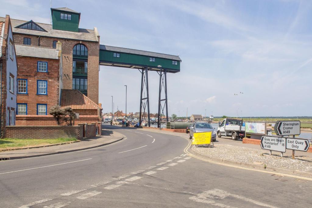 an empty road with a building and a street sign at Harbour View Cottage in Wells next the Sea