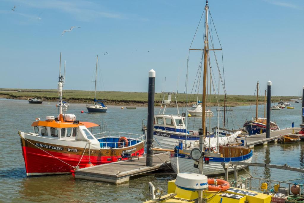 a group of boats are docked at a dock at Harbour View Cottage in Wells next the Sea
