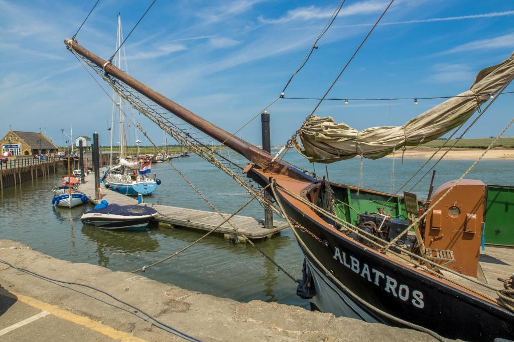 a group of boats are docked at a dock at Harbour View Cottage in Wells next the Sea