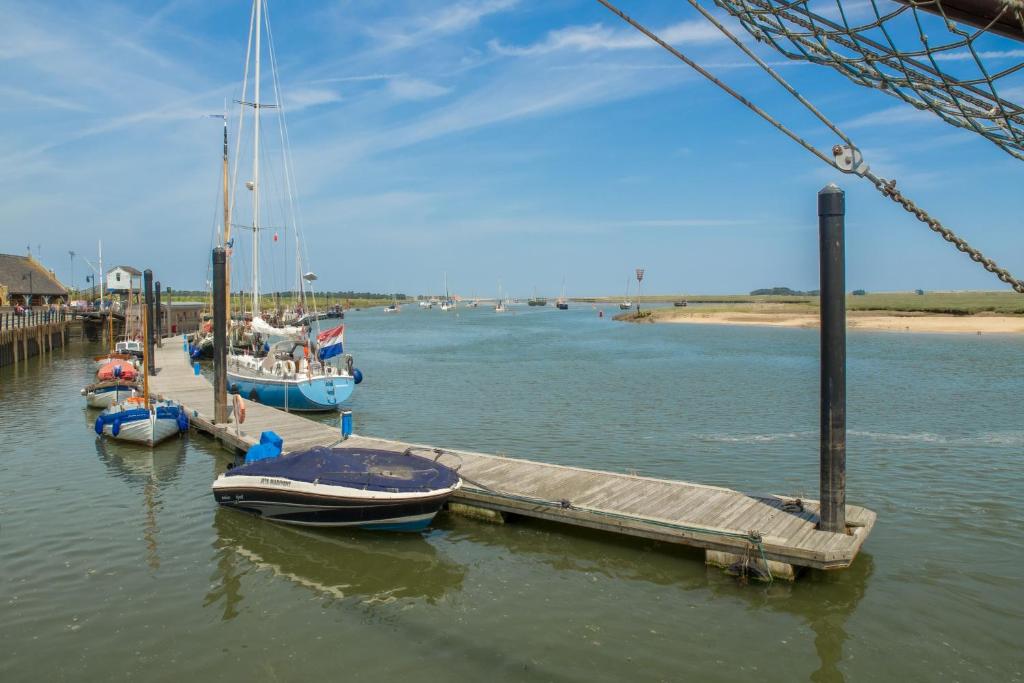 two boats are docked at a dock in the water at Harbour View Cottage in Wells next the Sea