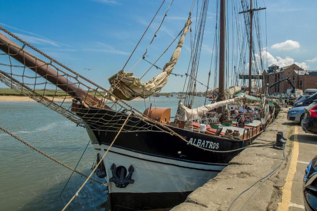a boat is docked at a dock in the water at Harbour View Cottage in Wells next the Sea
