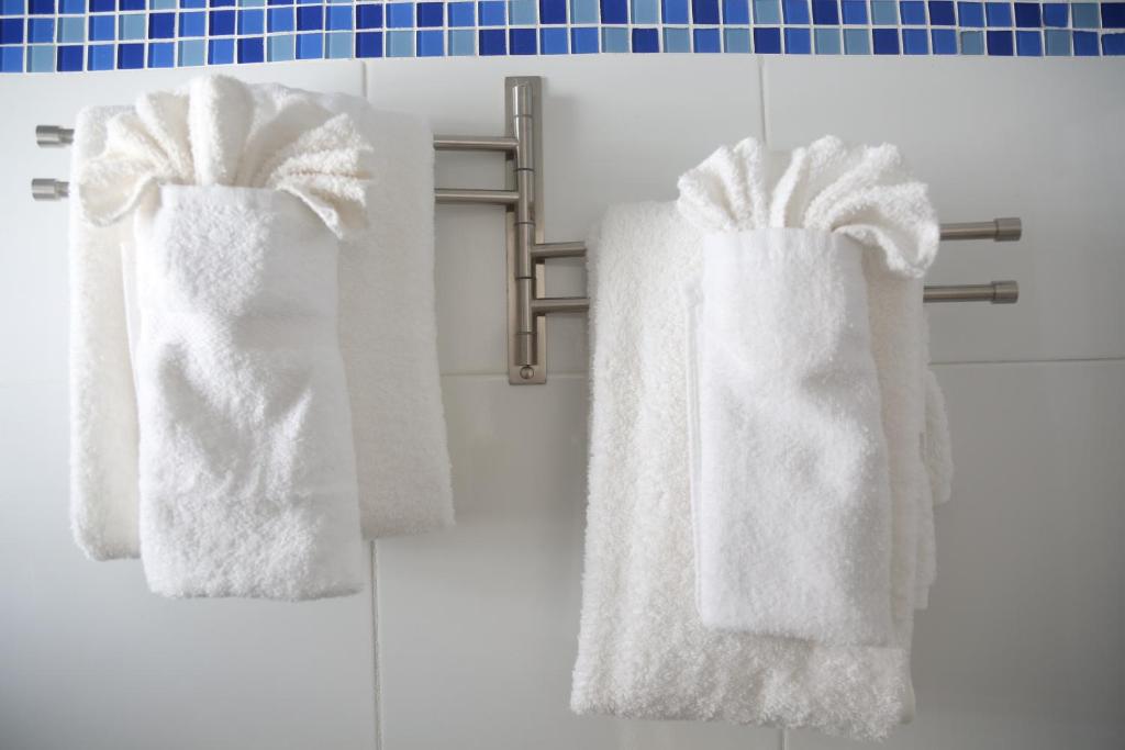 3 asciugamani appesi a un portasciugamani in bagno di Begona Cliff Hotel a Negril
