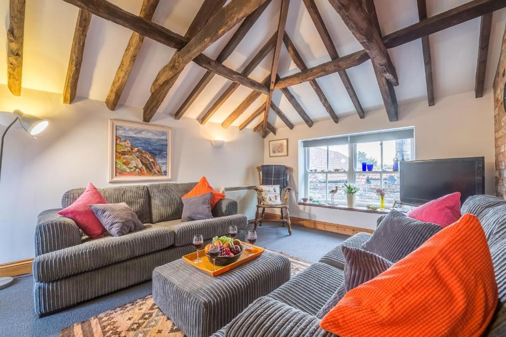 a living room with two couches and a tv at Newgates Cottage in Wells next the Sea