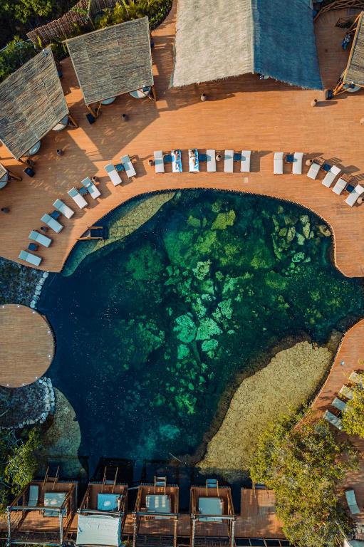an overhead view of a pool with tables and chairs at Hotel Shibari - Restaurant & Cenote Club in Tulum