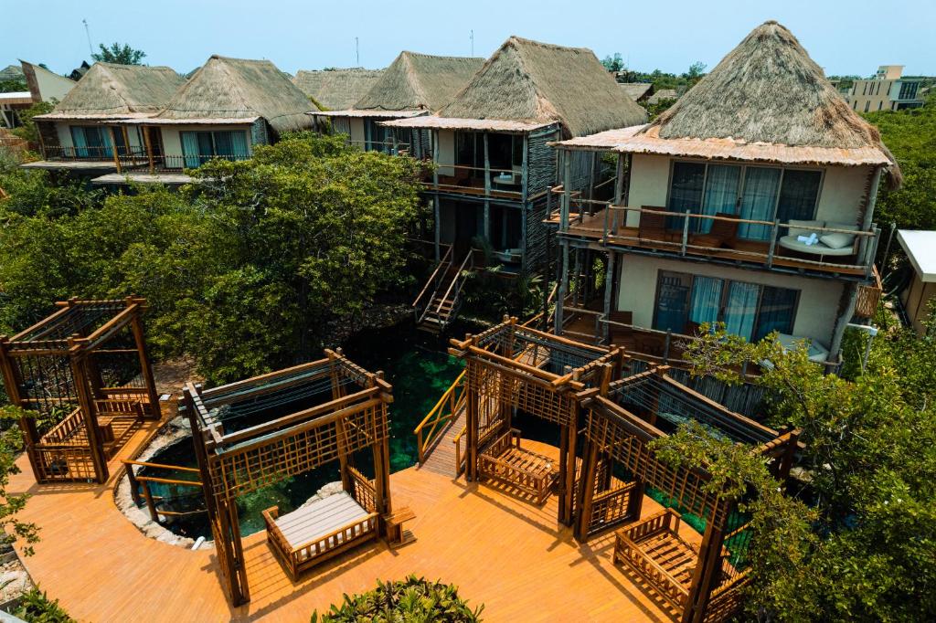 an aerial view of a building with thatched roofs at Hotel Shibari - Restaurant & Cenote Club in Tulum