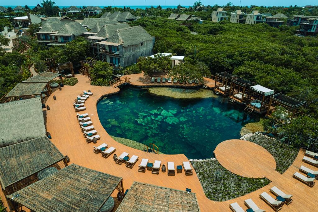 vista aerea su una piscina con sedie a sdraio di Hotel Shibari - Restaurant & Cenote Club a Tulum