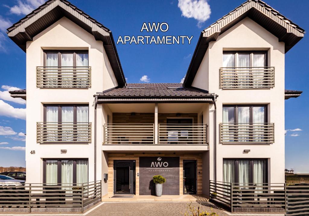 a large white building with the words awoarma apartment at AWO Apartamenty in Łeba